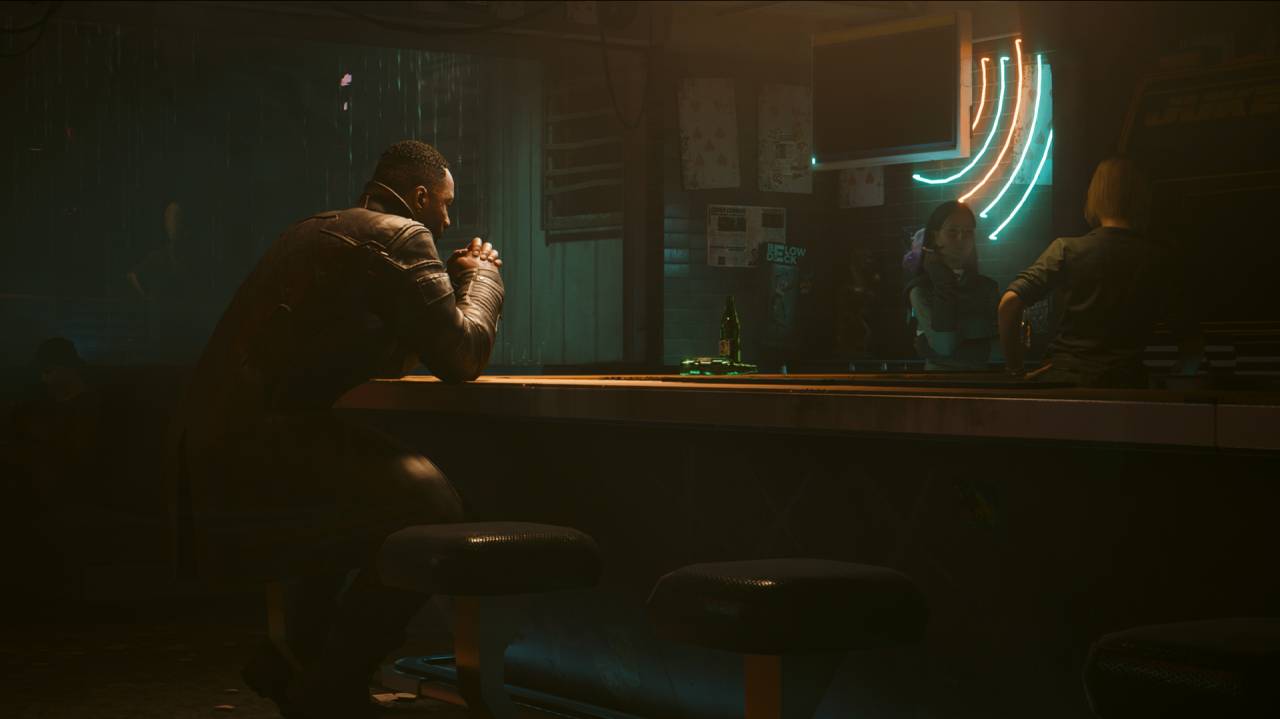 Idris Elba's character sitting at a bar in Cyberpunk 2077: Phantom Liberty.